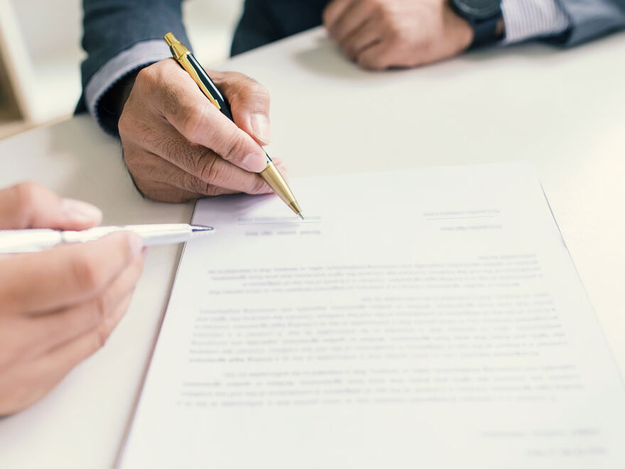 Two male hands showing signing a document.